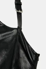 Top de cuello halter con hebilla metálica ajustable, diseño sin mangas y espalda descubierta. Presenta frunces laterales que crean un efecto drapeado y un bajo asimétrico. Cuenta con cierre lateral con cremallera oculta.