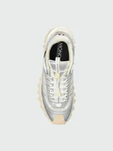 Zapatillas deportivas Moncler modelo Trailgrip GTX, con diseño técnico de trail running. Presentan una combinación de malla blanca y paneles de cuero sintético plateado, con suela Vibram de gran tracción en color crema y logo de la marca en el lateral.