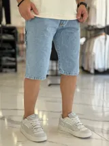 Bermuda de jean de corte baggy y tiro medio, con diseño clásico de cinco bolsillos y lavado claro.