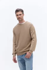 Sweater de cuello redondo color beige, con frente texturizado y mangas y espalda lisas. Presenta puños y ruedo acanalados.