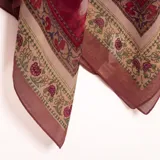Pashmina color bordó con diseño estampado de guardas ornamentales y detalles florales en tonos beige y verde.