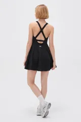 Vestido corto negro de poliamida, con diseño al cuerpo, breteles finos regulables y escote profundo.