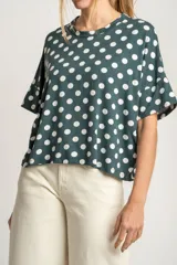 Remerón verde con lunares blancos, de calce oversize y mangas cortas.