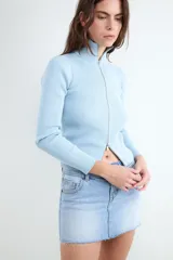Sweater de punto celeste con diseño acanalado, cuello alto y cierre frontal con doble cremallera metálica, de manga larga y calce al cuerpo.