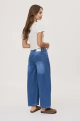 Jean de tiro medio y corte barrel con pierna amplia y ligeramente curva, estilo de cinco bolsillos en denim negro lavado.