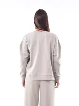 Buzo blanco de corte holgado, con cuello redondo y mangas largas.