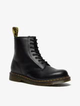 Botas de caña media Dr. Martens modelo 1460, color negro, con cierre de cordones de 8 ojales, costuras amarillas distintivas en la suela y lengüeta trasera con logo.