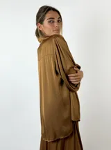 Blusa color bordó de mangas largas con puños elásticos y cuello camisero.