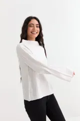 Sweater de tejido canalé en color blanco, con cuello alto y mangas largas de corte oxford. Presenta un diseño de ajuste holgado y textura acanalada vertical.