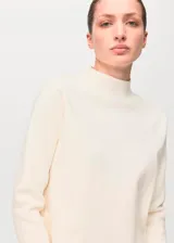 Sweater de punto fino color blanco off-white, con cuello perkins y manga larga, de corte recto.