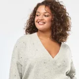 Sweater de punto gris melange con diseño cruzado tipo sobre, escote en V y mangas largas. Presenta detalles de strass dispersos por toda la prenda y terminaciones en tejido acanalado.