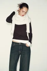 Camiseta de manga larga color gris melange, con cuello redondo y bajo recto. Presenta un detalle de tejido efecto doble a contraste en el cuello, puños y dobladillo inferior en color blanco.