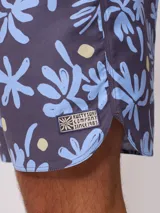 Short de baño Rusty con estampado de motivos botánicos y puntos amarillos sobre fondo azul. Cuenta con cintura elástica con cordón de ajuste y bolsillo lateral.