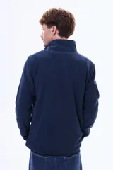 Buzo de micro polar azul marino con cuello alto y cierre frontal parcial. Presenta mangas largas y un diseño de calce cómodo.