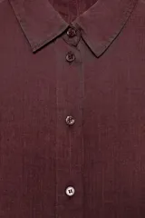 Camisa color borgoña de corte recto, con cuello solapa, manga corta y cierre frontal con botones.