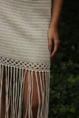 Falda tejida a mano en crochet, color crudo, con flecos en el ruedo y abertura lateral.