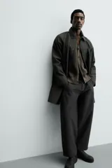 Gabardina impermeable de corte regular fit en color verde militar, con cuello solapa, manga larga con puño ajustable con botones a presión y bolsillos de vivo en la cadera. Cierre frontal con cremallera oculta por solapa con botones a presión.