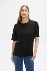 Remera negra de viscosa con textura acanalada, corte holgado y cuello redondo.