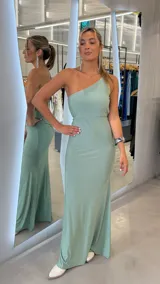 Vestido largo verde menta con diseño de un solo hombro y acabado brillante con lurex, de corte ajustado y caída fluida.