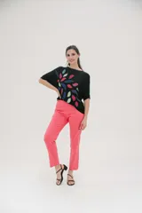 Remera negra de corte holgado con estampado de hojas de colores en el frente.