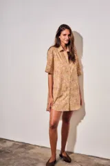 Vestido camisero corto con estampado tipo toile de Jouy a rayas, mangas cortas y cierre frontal con botones.