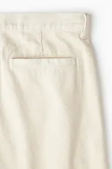 Pantalón de pana color beige, de corte relaxed fit, con cintura clásica, cierre de botón, bolsillos laterales y bolsillos traseros insertados.