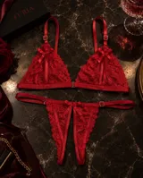 Conjunto de lencería rojo de encaje con diseño de aperturas, tiras regulables y detalles de moños satinados.