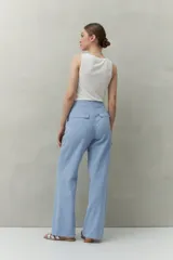Pantalón negro de corte recto y tiro alto, confeccionado en denim con costuras a contratono en color blanco. Presenta bolsillos frontales tipo parche y cierre frontal con botón y cremallera.
