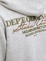 Hoodie gris melange de corte holgado, con capucha, bolsillo tipo canguro y pequeño estampado en el pecho. Confeccionado en tejido loopback con interior suavemente afelpado, puños y dobladillo acanalados.