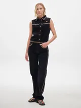 Pantalón de pana roja con corte holgado y tiro medio. Presenta una línea dorada a lo largo de la pierna.