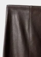 Falda midi de efecto piel, con diseño tipo lápiz, tiro medio y abertura posterior en el bajo. Cuenta con cierre de cremallera lateral.