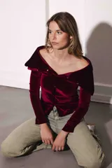 Remera color bordó de terciopelo con escote bardot y mangas largas.