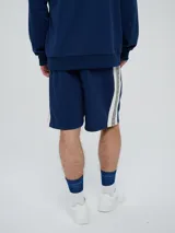 Bermuda de felpa azul marino con cordón ajustable en la cintura, bolsillos laterales y el logo de Umbro bordado en blanco en la pierna izquierda.