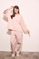 Sweater de punto con efecto jaspeado, de corte oversize, cuello redondo y mangas largas con terminación acampanada tipo volado.