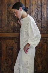 Blusa blanca con diseño calado, cuello mao y mangas 3/4 abullonadas.