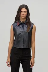 Chaleco negro de cuero con cuello camisero en color borgoña y azul, sin mangas y con cierre frontal de botones.