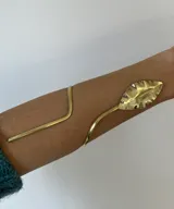 Brazalete dorado para el brazo con forma de hoja.