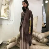 Poncho de lana merino afieltrada color marrón con cuello alto y abertura frontal.