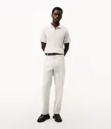 Remera polo marrón de tejido de tricot texturizado, de manga corta, con cuello polo abotonado y detalles de rayas blancas en el cuello.