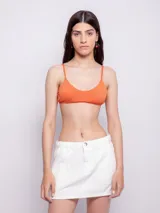 Top de bikini color naranja con textura animal print, breteles finos regulables, gancho en espalda, forro interior y copas desmontables.