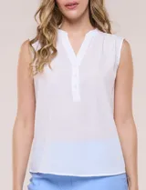 Blusa de gasa sin mangas de calce holgado, marca Sioni. Cuenta con cuello cadete, abertura frontal en V con media cartera de botones, espalda con canesú y pliegue central, y ruedo redondeado.