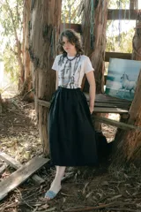 Falda midi de corte amplio con cintura elastizada y frunces laterales, confeccionada en tejido tipo gobelino con estampado floral sobre fondo azul.