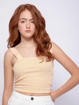 Top sin mangas con estampado de lunares, escote recto y tirantes anchos.