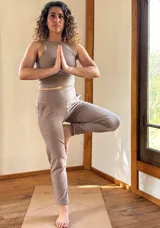 Conjunto deportivo compuesto por un top corto de escote redondo y un pantalón ajustado de tiro alto con faja ancha y bolsillos frontales y traseros.