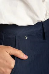 Pantalón wide leg de tiro medio y corte holgado, color azul marino, con pinzas en la parte frontal, bolsillos laterales y cierre con botón.