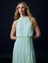 Vestido largo de gasa color verde menta, marca Julia Jordan. Tiene escote halter, cintura elastizada con lazo de ajuste y abertura central en la espalda con botones.