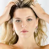 Aros colgantes de plata 950 con circonias rojas y diseño de círculos entrelazados.