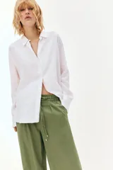 Pantalón de tiro alto con pernera ancha, confeccionado en tejido de lino. Presenta cintura elástica con cordón ajustable, pinzas delanteras, bolsillos laterales y bolsillos de plastrón en la parte posterior.