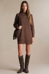 Vestido corto de punto con cuello polera, manga larga y puños acanalados. Presenta un diseño liso y holgado con terminación acanalada en el ruedo.