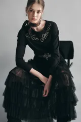 Remera de manga larga y calce relajado, confeccionada en algodón negro. Presenta un escote redondo y un bordado decorativo de piedras en el pecho con la frase 'Mon Amour'.